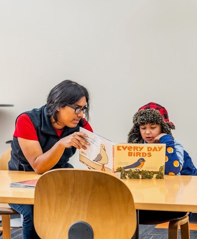 An adult and a child reading a book together